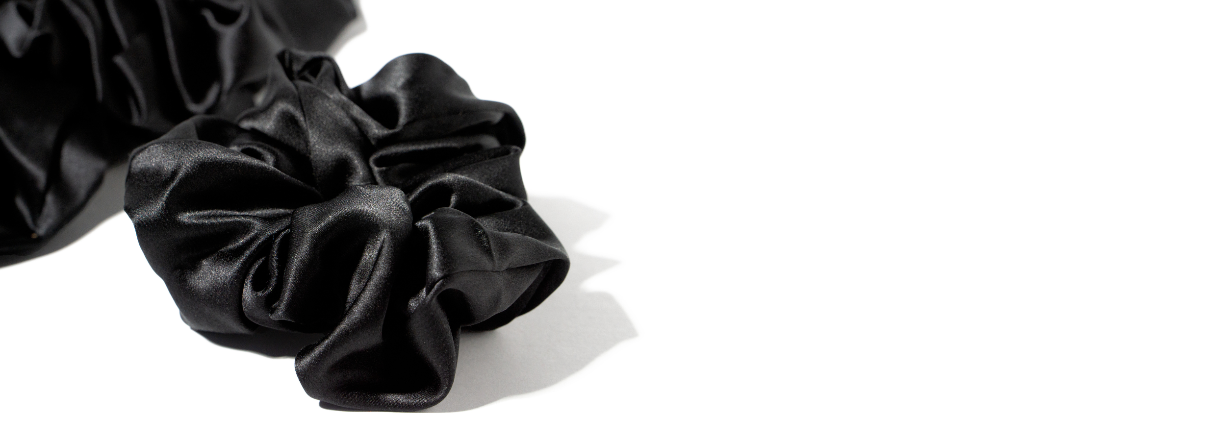 aloe black premium silk scrunchies on a plain